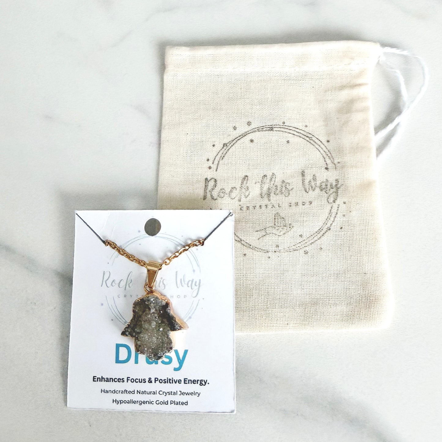 Gold plated Hamsa drusy hand pendant necklace displayed on Rock This Way Crystal Shop packaging, ready for gifting.