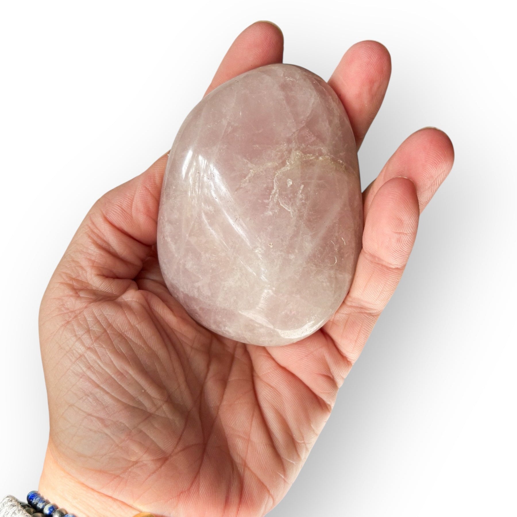 Hand holding polished Rose Quartz crystal to show medium size.