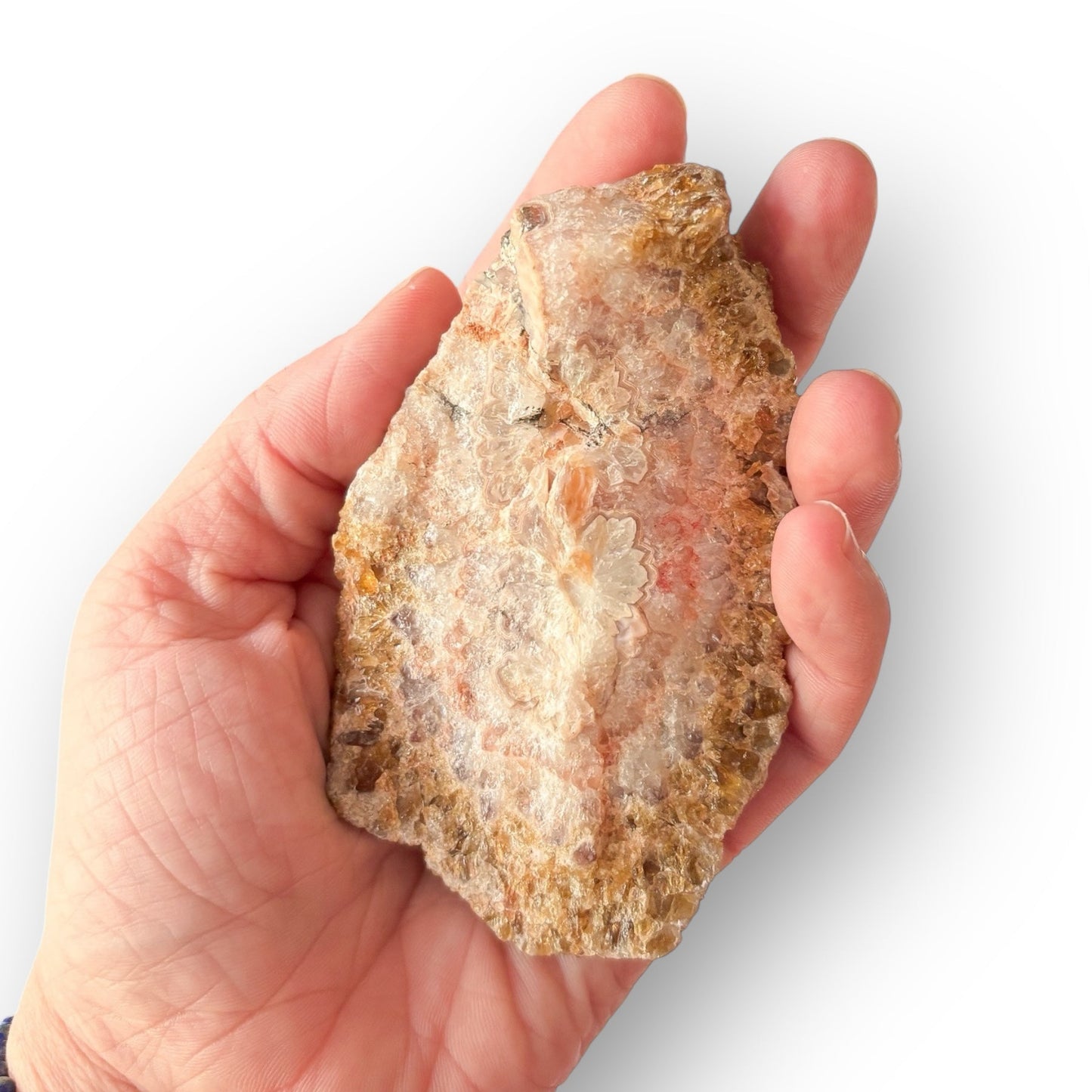Hand holding Red-Orange Botryoidal Aragonite crystal to show natural size and shape.