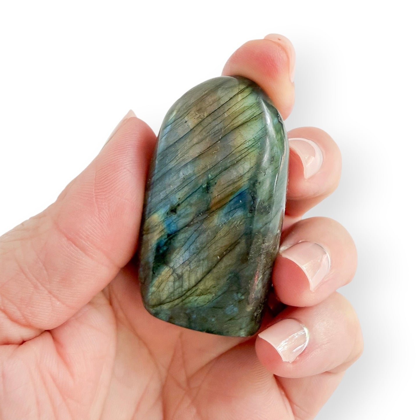 Hand holding a Labradorite free form showing natural green, gray, and blue coloration.