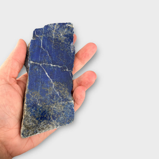 Lapis Lazuli blue crystal slab held in hand, showing long shape and detail