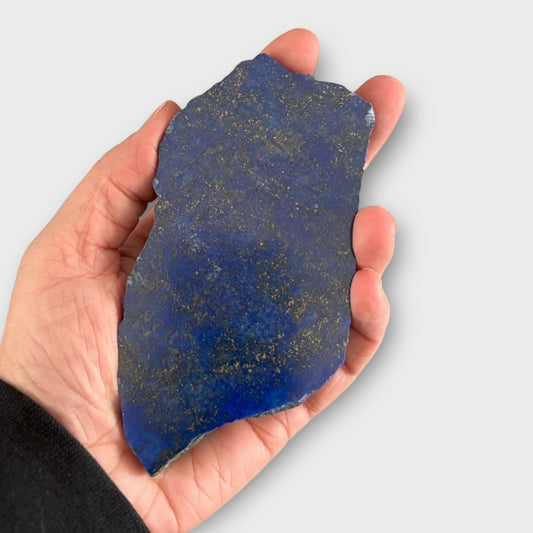 Lapis Lazuli slab held in hand showing size and polished surface