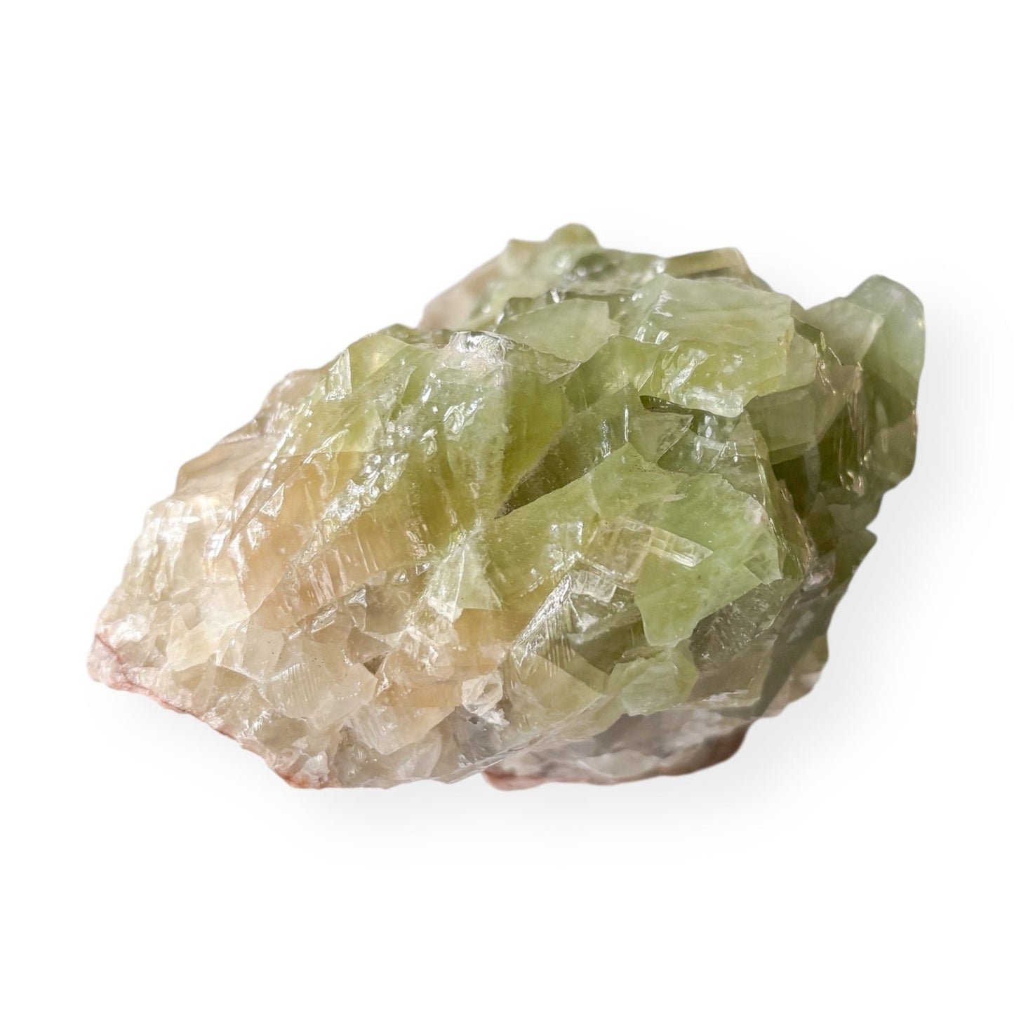Large Green Calcite cluster with layered green and cream crystals on a red matrix, natural raw formation.
