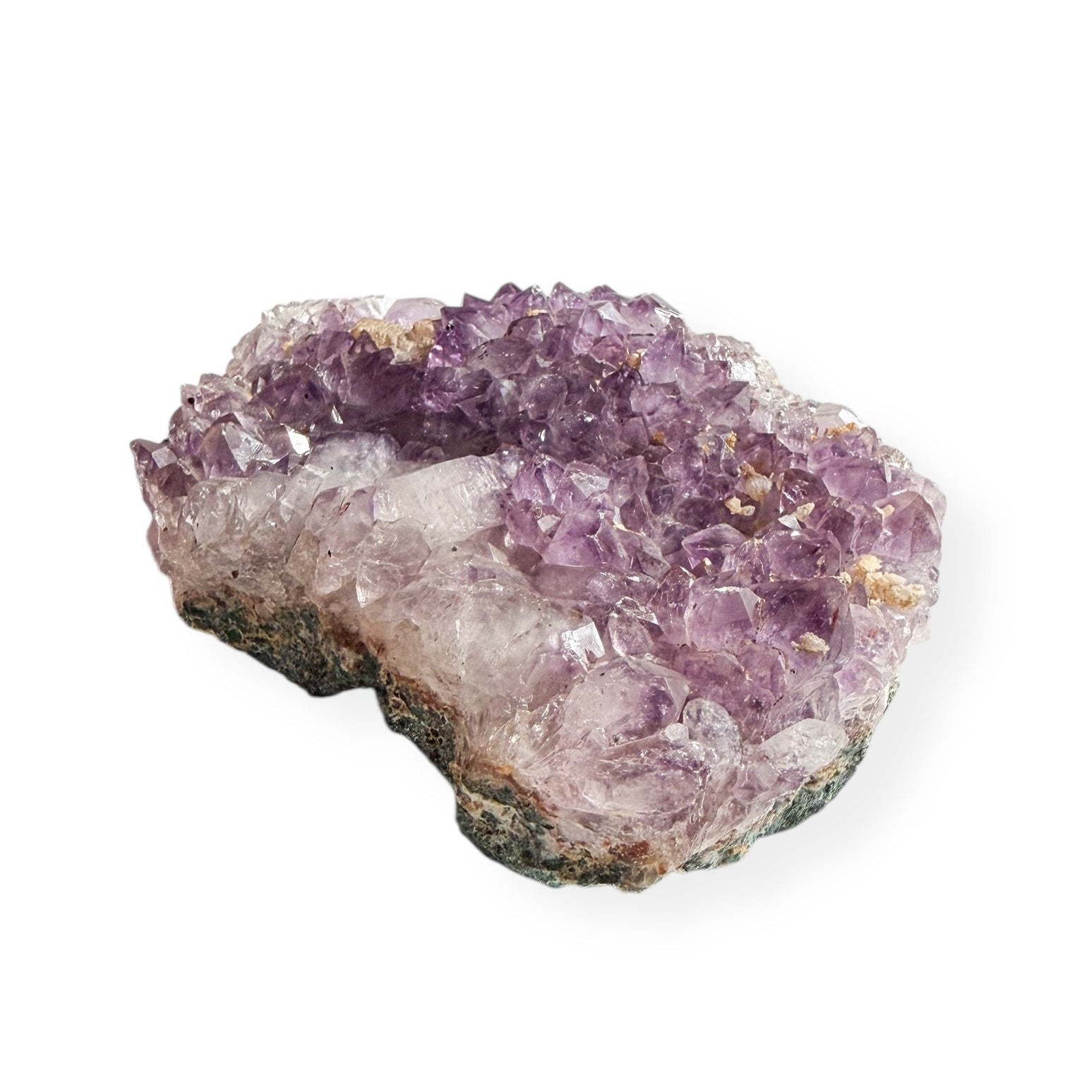 Back view showing green and brown base of natural amethyst cluster in hand