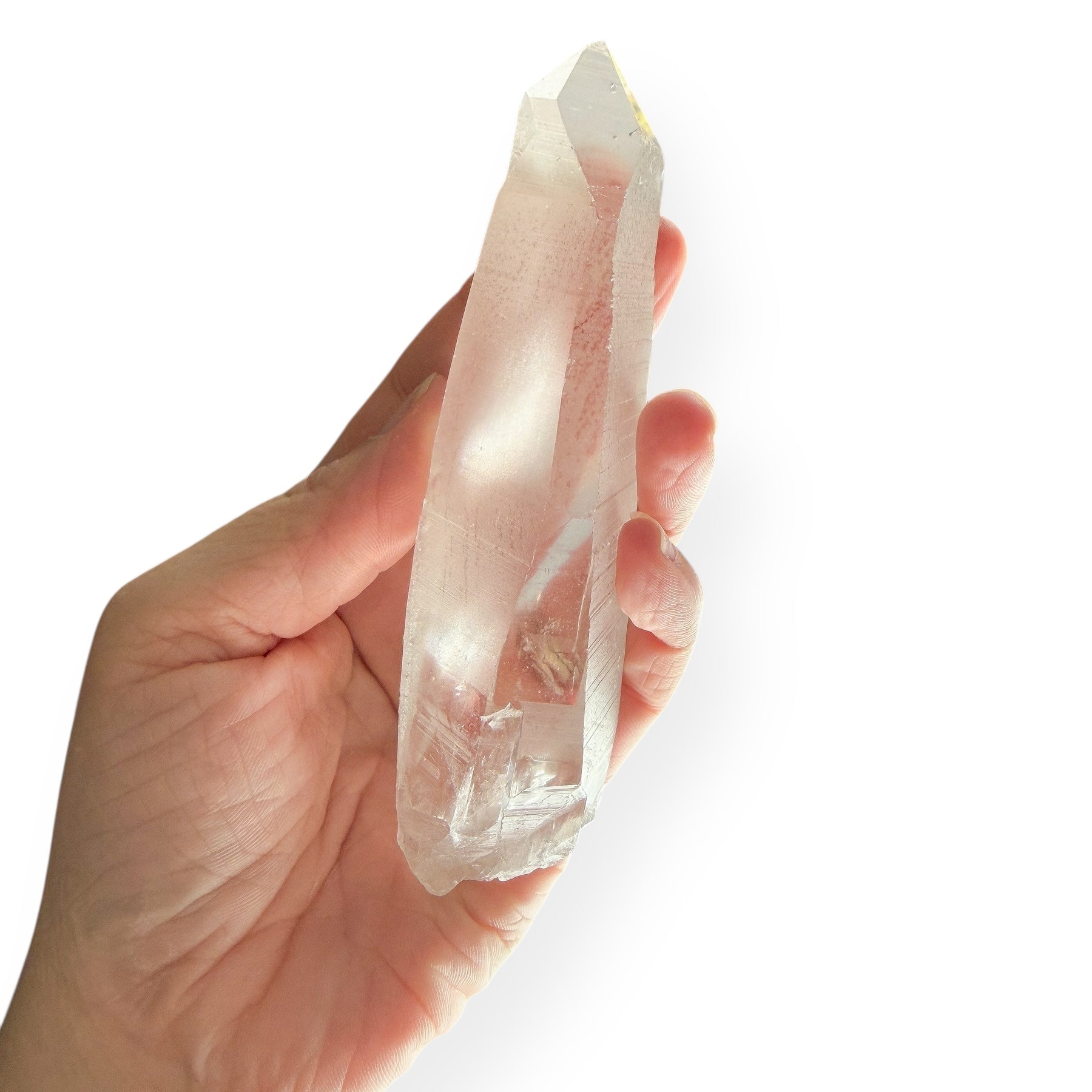 Hand holding Lemurian Quartz Wand to show size and transparency