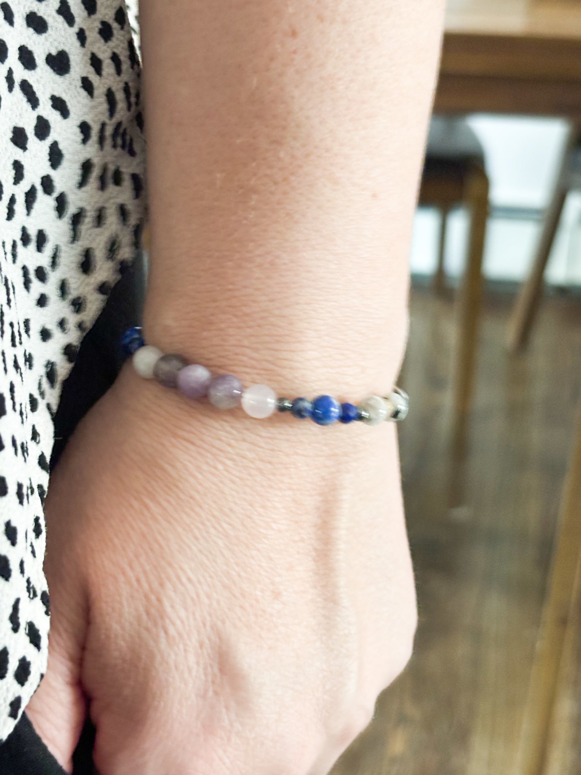 Libra Crystal Charm Bracelet with a white charm worn on wrist, highlighting its lightweight and flexible fit.