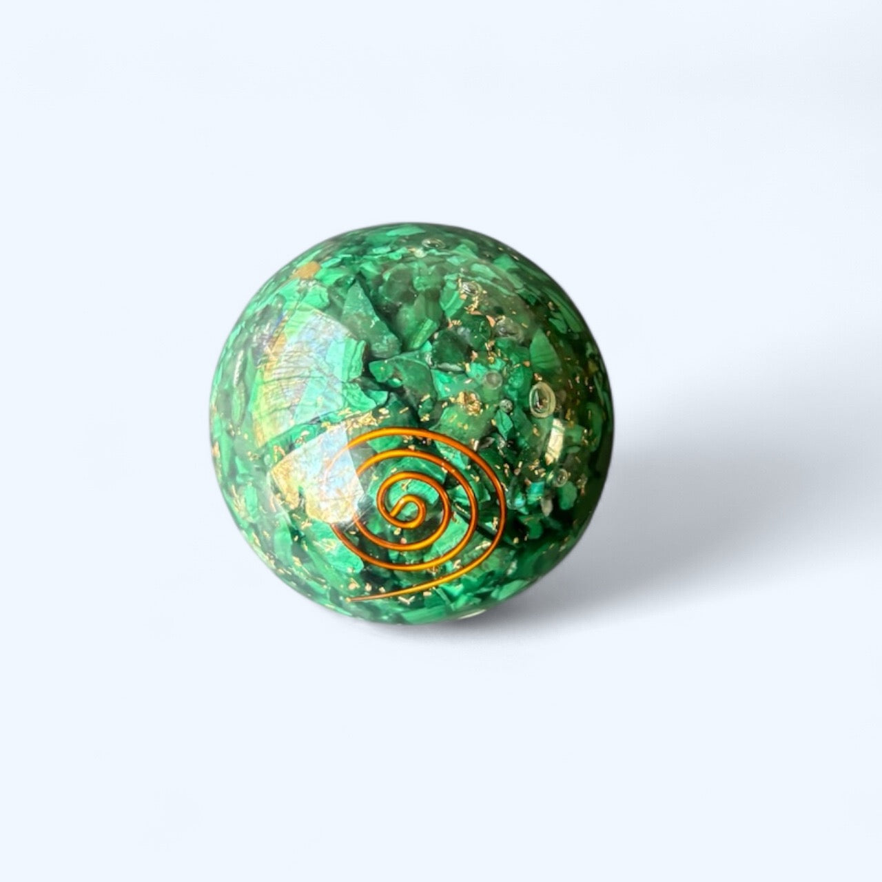 Top view of Malachite Orgone Sphere showing crystal chips and embedded copper spiral