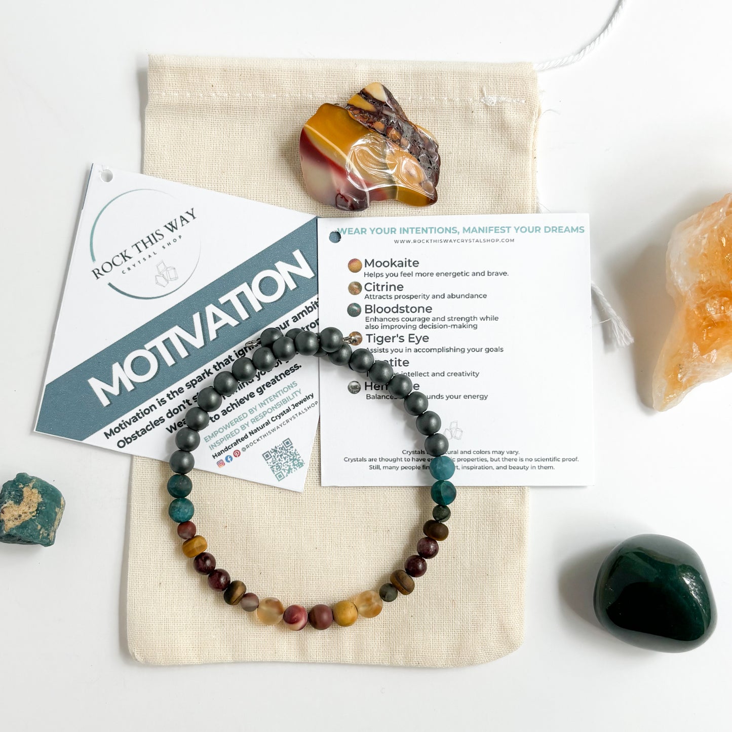 Men’s Motivation Bracelet shown with meaning card and gift pouch, styled with natural stones