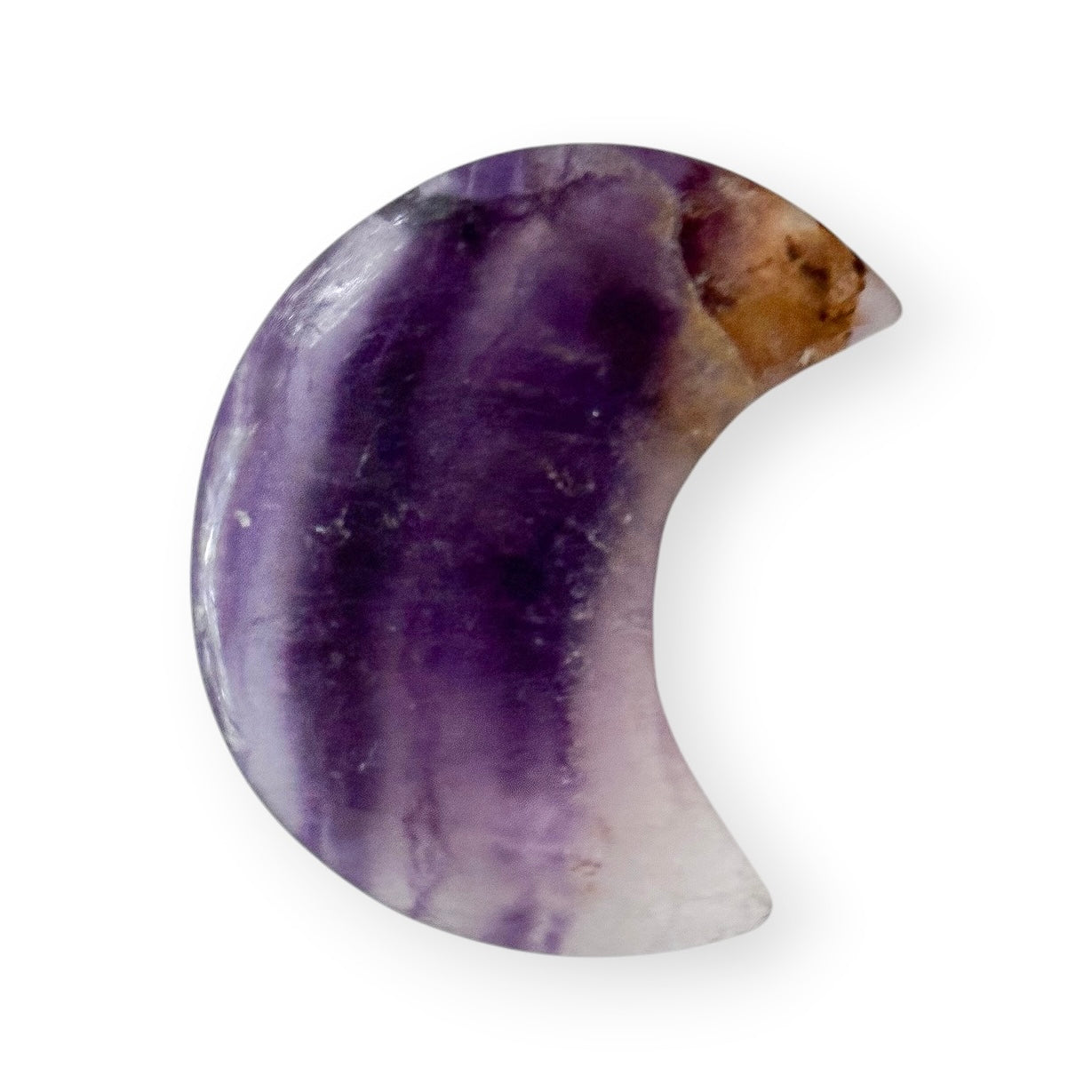 Natural purple fluorite crescent moon carving displaying layered purple banding and polished crystal surfaces.