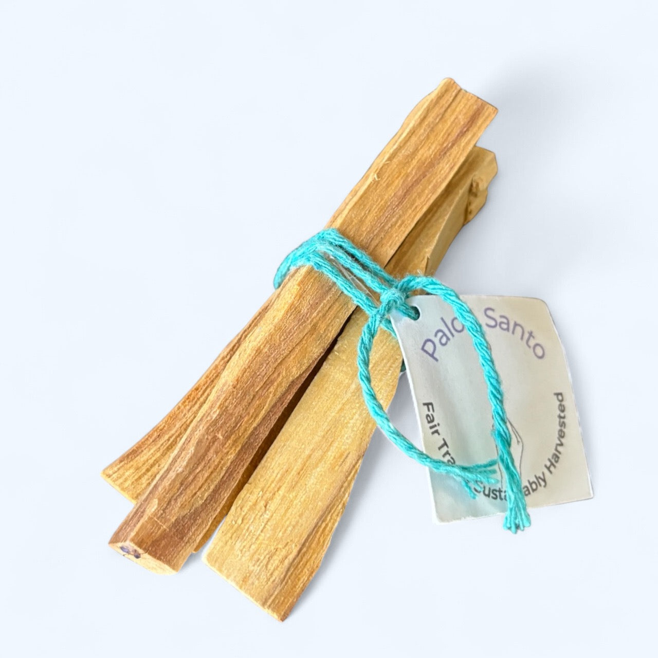 Three Palo Santo sticks arranged in a natural bundle on white background