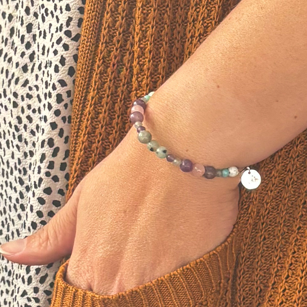 Patience Bracelet styled on wrist with gold-tone band and natural light