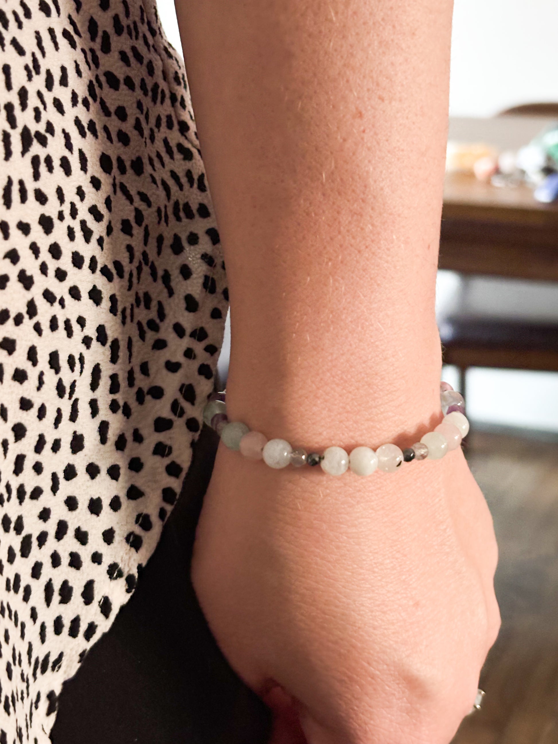 Pisces Crystal Charm Bracelet with a white charm worn on wrist, highlighting its comfortable, adjustable fit.
