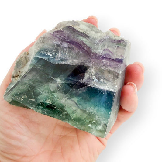 Rainbow Fluorite freeform held in hand for size reference, featuring polished and natural surfaces.