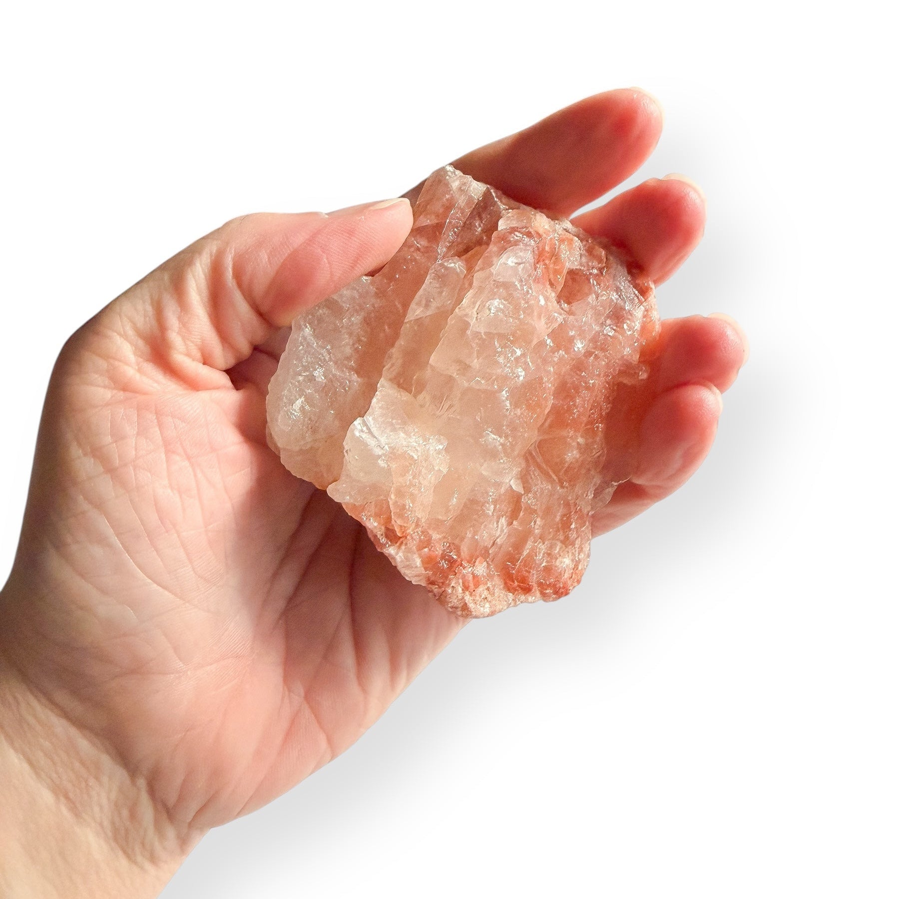 Raw Red Calcite displayed in hand for size reference