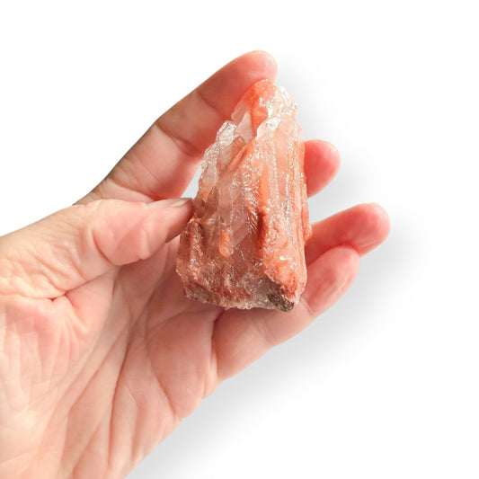 Raw Red Calcite displayed in hand for size reference