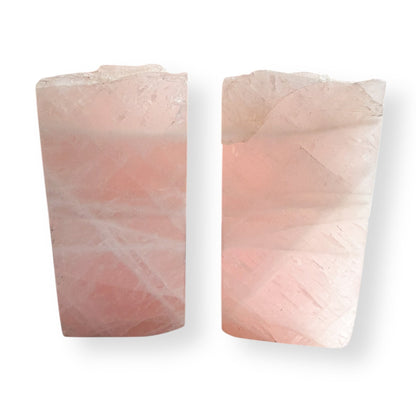 Side view of rose quartz crystal bookends showing natural stone texture and blush pink color tones.