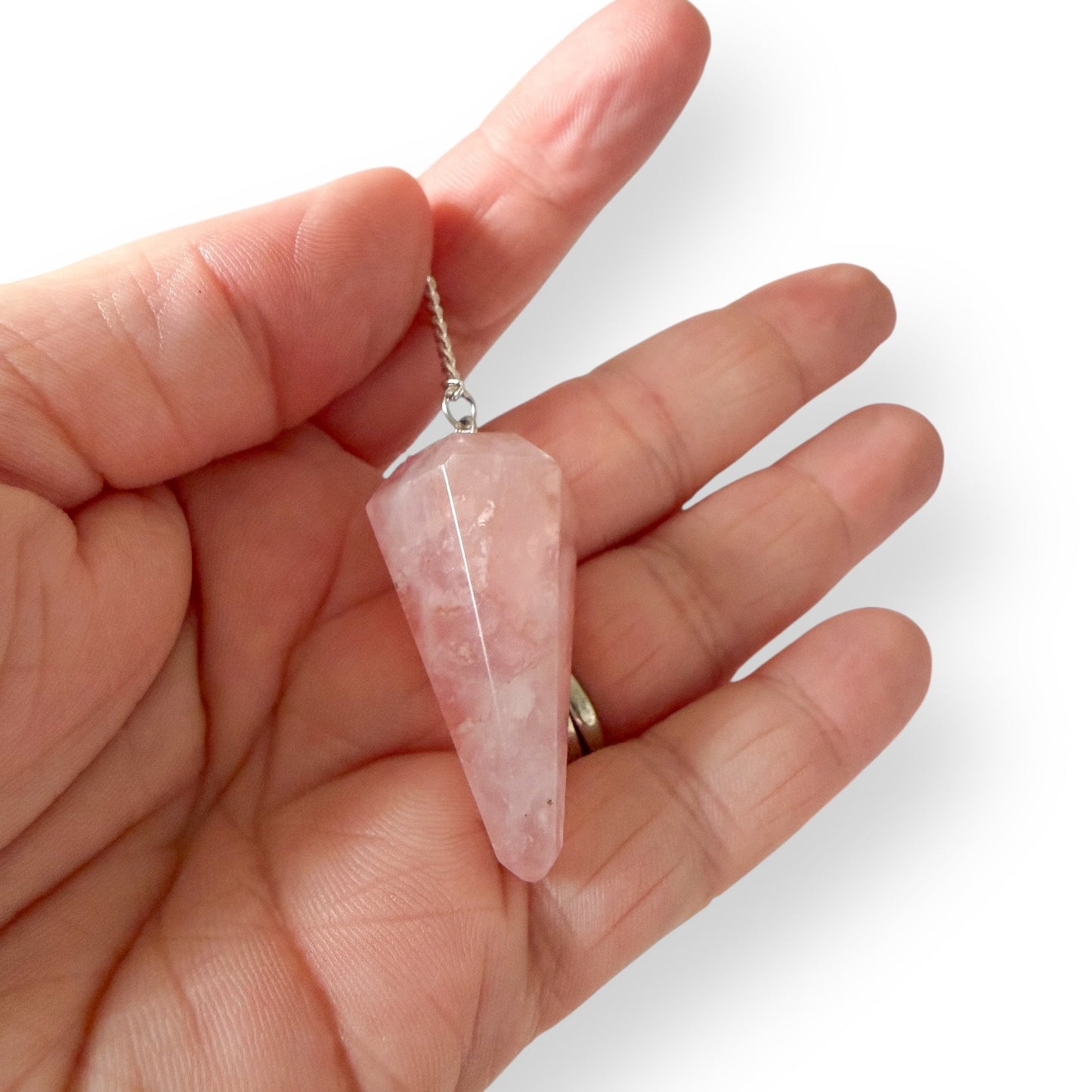 Close-up of natural Rose Quartz dowsing pendulum with soft pink crystal and silver chain