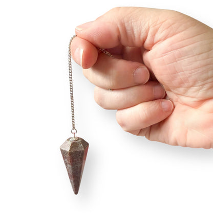 Ruby in Kyanite pendulum shown in hand to display size, color, and polished finish