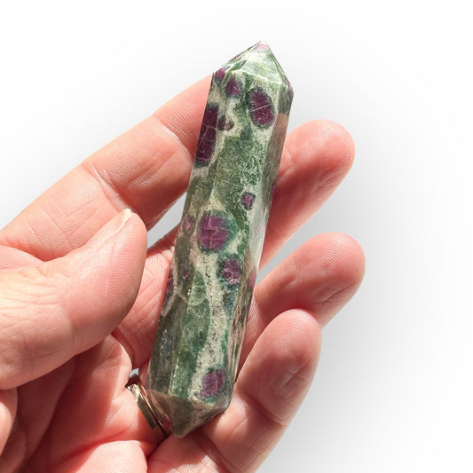 Ruby in Zoisite wand shown in palm to highlight crystal size and color variation.