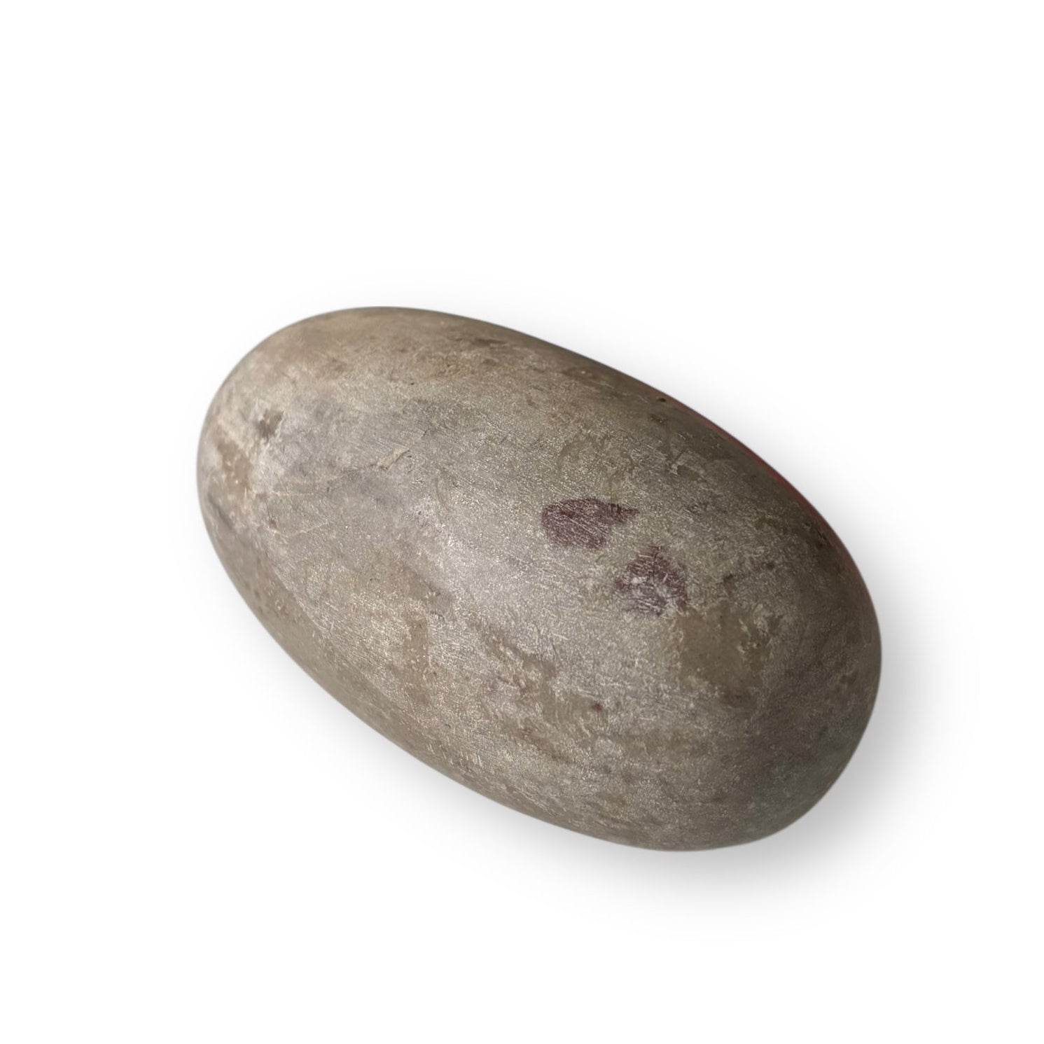 Shiva Lingam Stone B displayed on surface, highlighting natural color variations and balanced shape.