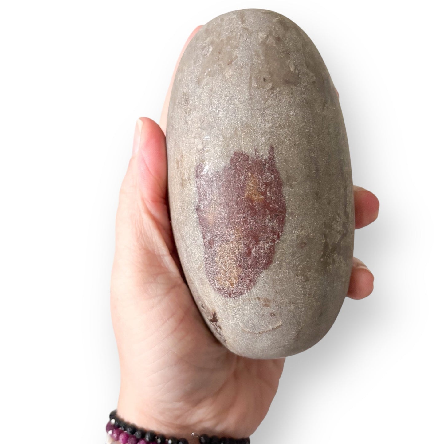 Shiva Lingam Stone B in soft taupe and brown tones, naturally shaped by river currents in India.