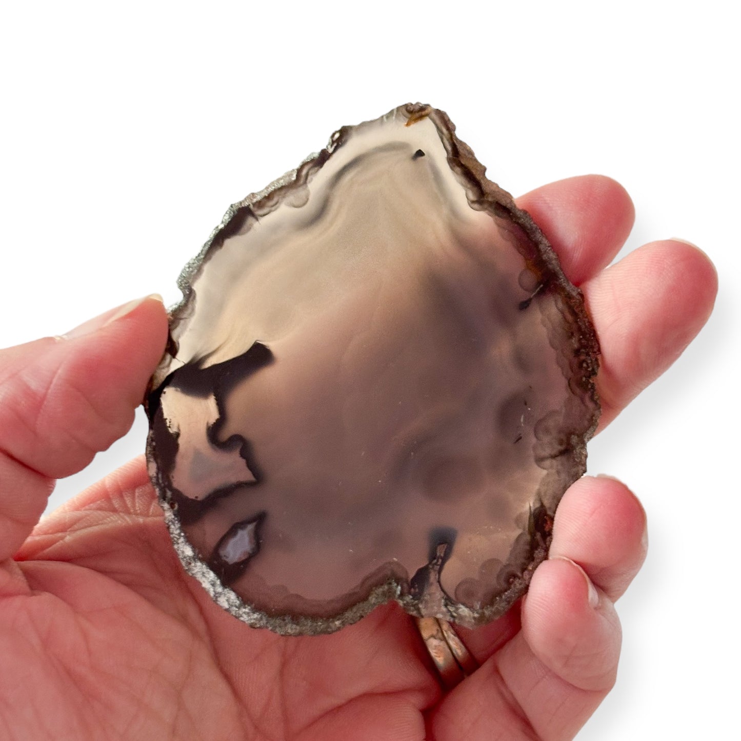 Hand holding gray and black agate slice showing texture