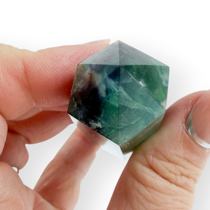 Small Rainbow Fluorite obelisk held between fingers for size