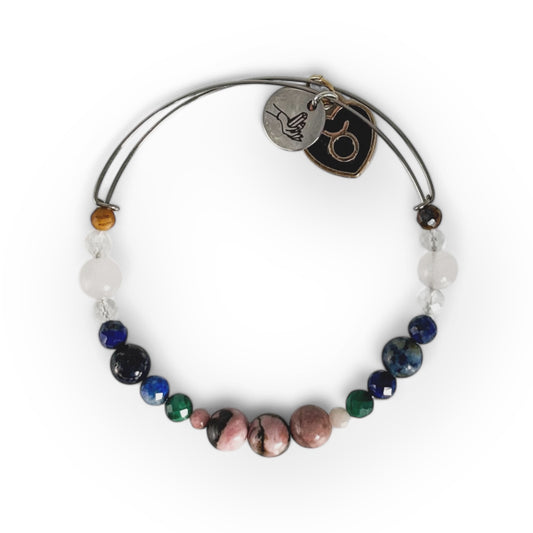 Taurus Crystal Charm Bracelet with a black charm, featuring Rhodonite, Malachite, Lapis Lazuli, Clear Quartz, Rose Quartz, and Tiger’s Eye for grounding and emotional balance.