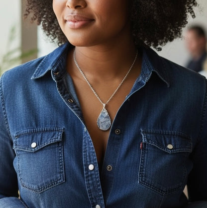 Modeled view of a silver plated teardrop drusy pendant necklace on a stainless steel chain, shown in an AI generated lifestyle image.