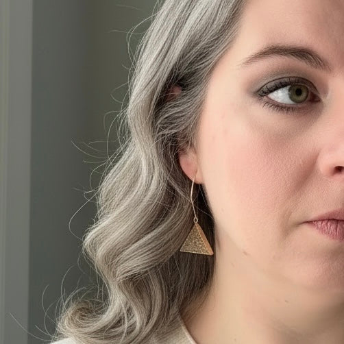 Model wearing triangle drusy earrings with gold filled wires, showing a subtle sparkle and modern triangle shape