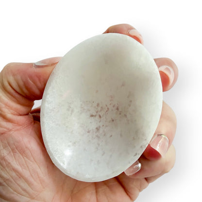 Handheld white Satin Spar oval bowl carved from natural crystal with a smooth polished finish.