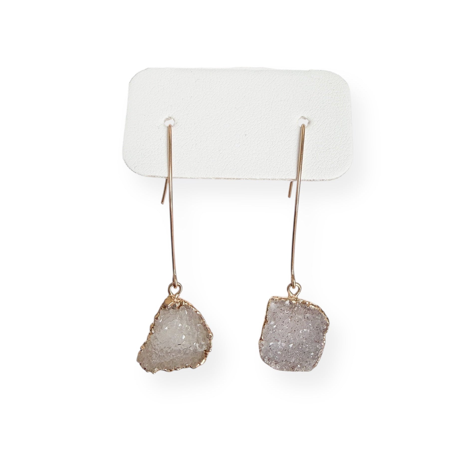 Close up of white squoval freeform drusy crystal earrings showing natural texture and sparkling crystal surface in gold filled setting